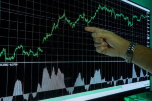 Gráfico que muestra un análisis de datos financieros con una mano señalando las tendencias del mercado.